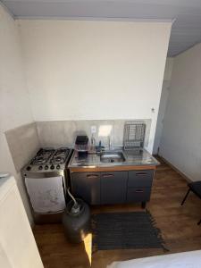 a small kitchen with a stove and a sink at Lindo Apto Mobiliado, Smart TV - Caieras in Caieiras