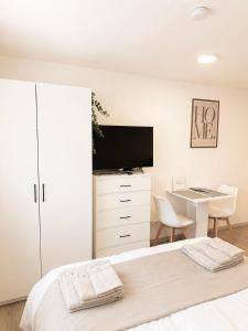 a bedroom with a bed and a desk and a tv at STAY - Comfort Apartment in Friedrichshafen