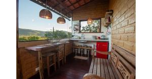 a kitchen with a counter and a large window at Lilás Hospedagem e Terapias in Vale do Capao