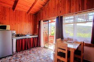 a kitchen with a table and a refrigerator and a counter at Hotel Mango Valley in Grecia