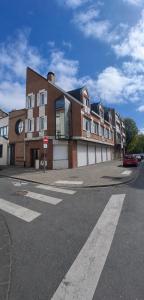 a large brick building on the corner of a street at Appartement neuf & élégant Centre Dunkerque rue de la porte d'eau in Dunkerque