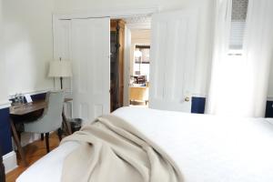 a bedroom with a white bed and a desk and a table at The West End Collection on Pine in Portland