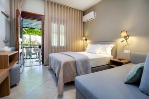a hotel room with two beds and a balcony at Studios Panagiotas House Astris in Astris