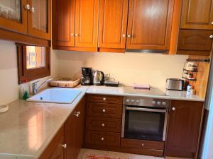 a kitchen with wooden cabinets and a sink at Like a local in Chios Castle in Chios