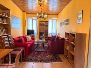 a living room with a red couch and a tv at Like a local in Chios Castle in Chios