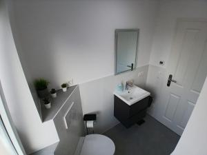 a white bathroom with a toilet and a sink at City Hub Room 27 - Coffee for free - in Karlsruhe