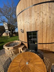 a wooden building with a fountain and a wooden table at La Cabane Tonneau - Les Pieds dans le Pré in Les Landes-Génusson +30 photos
