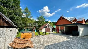 a house with a brick patio and a house at Chalupa Martinček in Terchová