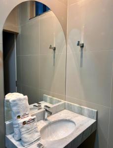 a bathroom with a sink with a mirror and towels at Hotel Matinha in Campinorte