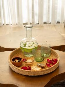 a glass vase and glasses on a tray on a table at Alyasa Village in Jbeil