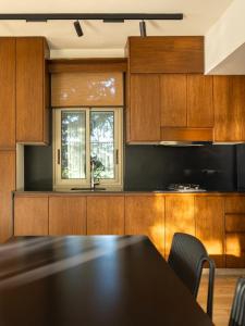 a kitchen with wooden cabinets and a table with chairs at Alyasa Village in Jbeil