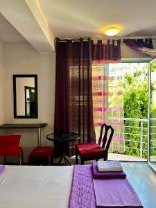a room with a bed and chairs and a window at Adzija House in Ohrid