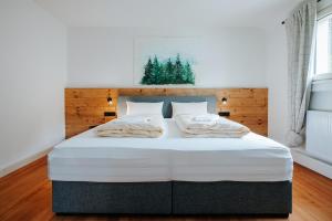 a bedroom with a large white bed with a wooden headboard at Frisch sanierte Wohnung mit zwei Schlafzimmern in historischem Baudenkmal in Feldberg