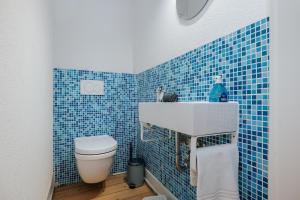 a blue tiled bathroom with a toilet and a sink at Frisch sanierte Wohnung mit zwei Schlafzimmern in historischem Baudenkmal in Feldberg +16 photos