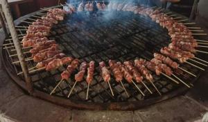 a bunch of meat cooking on a grill at Pangeo forest village in Mousthéni