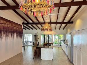 a large kitchen with a large chandelier and a table at Turtle Bay Beach House in Saraotou