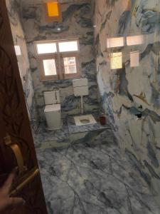 a bathroom with two toilets and a stone wall at Younis Guest house in Srinagar