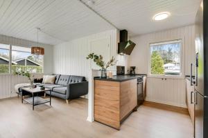 a kitchen and living room with a couch and a table at C11347-Tarm-Baeverstien-8 in Tarm