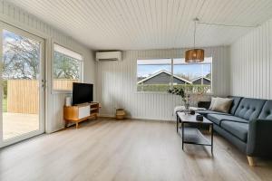 a living room with a blue couch and a tv at C11347-Tarm-Baeverstien-8 in Tarm