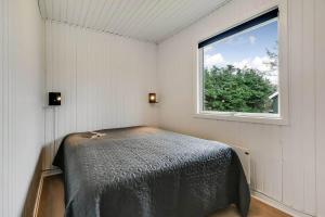 a bedroom with a bed in a room with a window at C11347-Tarm-Baeverstien-8 in Tarm