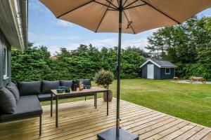 a patio with a couch and a table with an umbrella at C11347-Tarm-Baeverstien-8 in Tarm