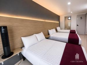 a hotel room with two beds and a tv at Hotel Casa Galeana Centro con Estacionamiento Privado in Aguascalientes +18 photos