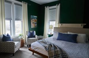 a bedroom with green walls and a bed with blue pillows at The West End Collection on Pine in Portland