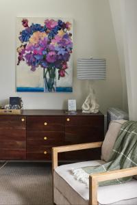 a living room with a dresser and a painting of flowers at The West End Collection on Pine in Portland +18 photos