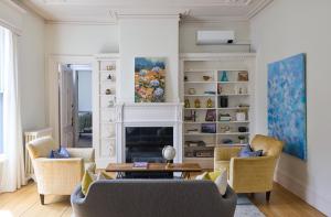 a living room with two chairs and a fireplace at The West End Collection on Pine in Portland