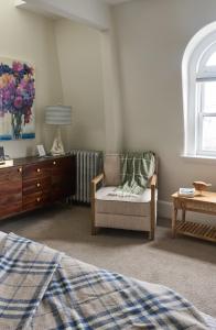 a bedroom with a bed and a chair and a dresser at The West End Collection on Pine in Portland