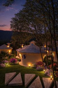 a house with lights in a yard at night at Divlja dolina in Budva