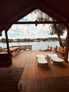 a wooden deck with benches and a view of the water at Vikendica Eldar, Ada Bojana in Ulcinj