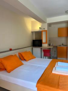 a bedroom with a large white bed with orange pillows at Adzija House in Ohrid +23 photos