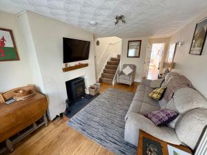a living room with a couch and a fireplace at Charming 2 bedroom cottage in Brecon - families and pets welcome! in Brecon