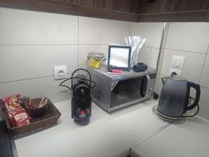 a kitchen counter with a microwave and a blender at Airport Anasta Casa in Artemida