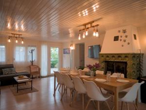 a dining room with a table and a fireplace at Rózsa Villa Vadkerti tó in Soltvadkert
