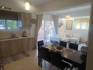 a kitchen and living room with a table and a couch at Airport Anasta Casa in Artemida
