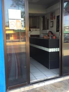 una persona sentada en el mostrador de un restaurante en Hotel Paraiso Express, en Veracruz