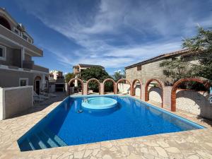 a large blue swimming pool next to a building at Vila Kula in Nin