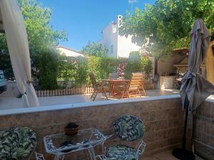 a patio with a table and chairs on a balcony at Airport Anasta Casa in Artemida