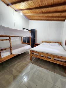 a bedroom with two bunk beds and a wooden ceiling at Cabaña Florez in Santa Marta