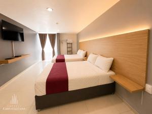 a hotel room with two beds and a flat screen tv at Hotel Casa Galeana Centro con Estacionamiento Privado in Aguascalientes