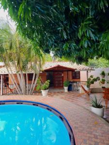 a swimming pool in front of a house at Cabaña Florez in Santa Marta