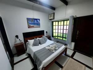 a bedroom with a bed with an elephant towel on it at Pousada Casa da Pedra in Búzios