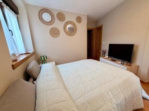 a bedroom with a bed and two mirrors on the wall at Monte Subiedes, Apartamentos Valle de Camaleño in Camaleño