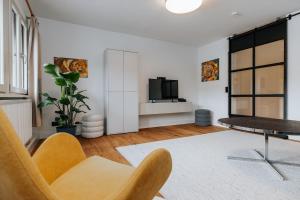 a living room with a table and a tv at Top sanierte, gehoben ausgestattete Wohnung für 2-4 Personen in Baudenkmal in Feldberg