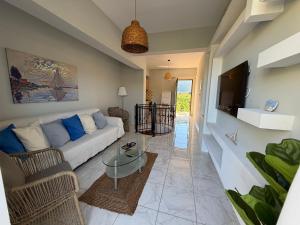 a living room with a couch and a tv at Το Είδωλον Sea Maisonettes & Studio in Ancient Epidauros