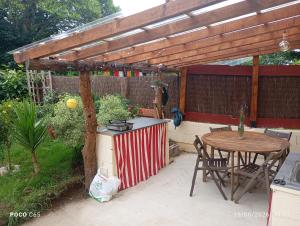 a patio with a table and a wooden pergola at Estación celorio in Celorio +4 photos