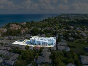 an aerial view of a building with the ocean in the background at Modern 2BR Beachside Haven Ground Floor and Pool in Saint Peter