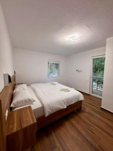 ein Schlafzimmer mit einem großen Bett und einem Fenster in der Unterkunft Riverside in Valbonë